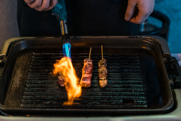 bunsenbrenner-fleisch Fleisch wird mit Bunsenbrenner gegrillt