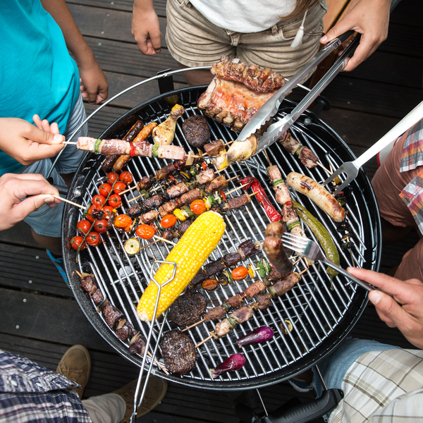 runder Grill von oben mit Händen, die Grillzangen halten
