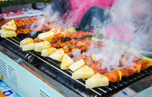 dampfende Spieße mit Fleisch und Ananas auf dem Grill