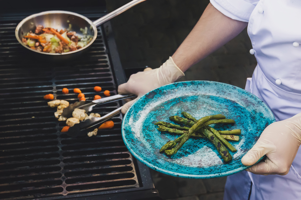 Koch grillt Spargel auf Gasgrill