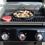 Fleisch und Pilze werden auf einem Gasgrill gegrillt